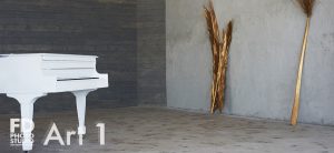 natural light photo studio with white staircase, white grand piano, concrete and wood walls and gold-sprayed branches