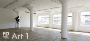 natural light photo studio with white staircase, white grand piano, concrete and wood walls