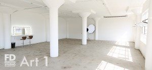 natural light photo studio with white staircase, white grand piano, concrete and wood walls