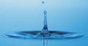 Drop of water falling in puddle
