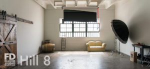 South-East Facing Natural light photo studio with wood barn doors, wood barrels and red phone booth