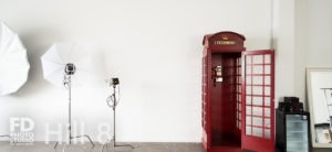 South-East Facing Natural light photo studio with wood barn doors, wood barrels and red phone booth