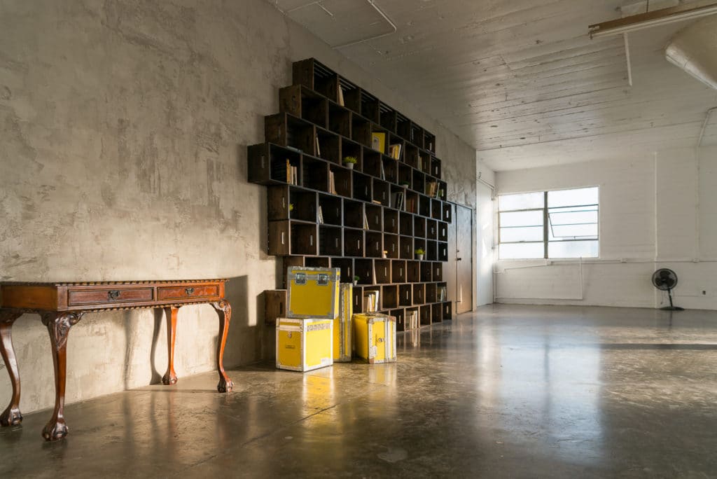 Photo Studio with Book Shelf, yellow cine cases and grey textured wall