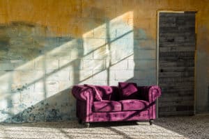 Sunshine studio 7 with a yellow textured wall, moroccan tile and a purple couch available for rental in NYC