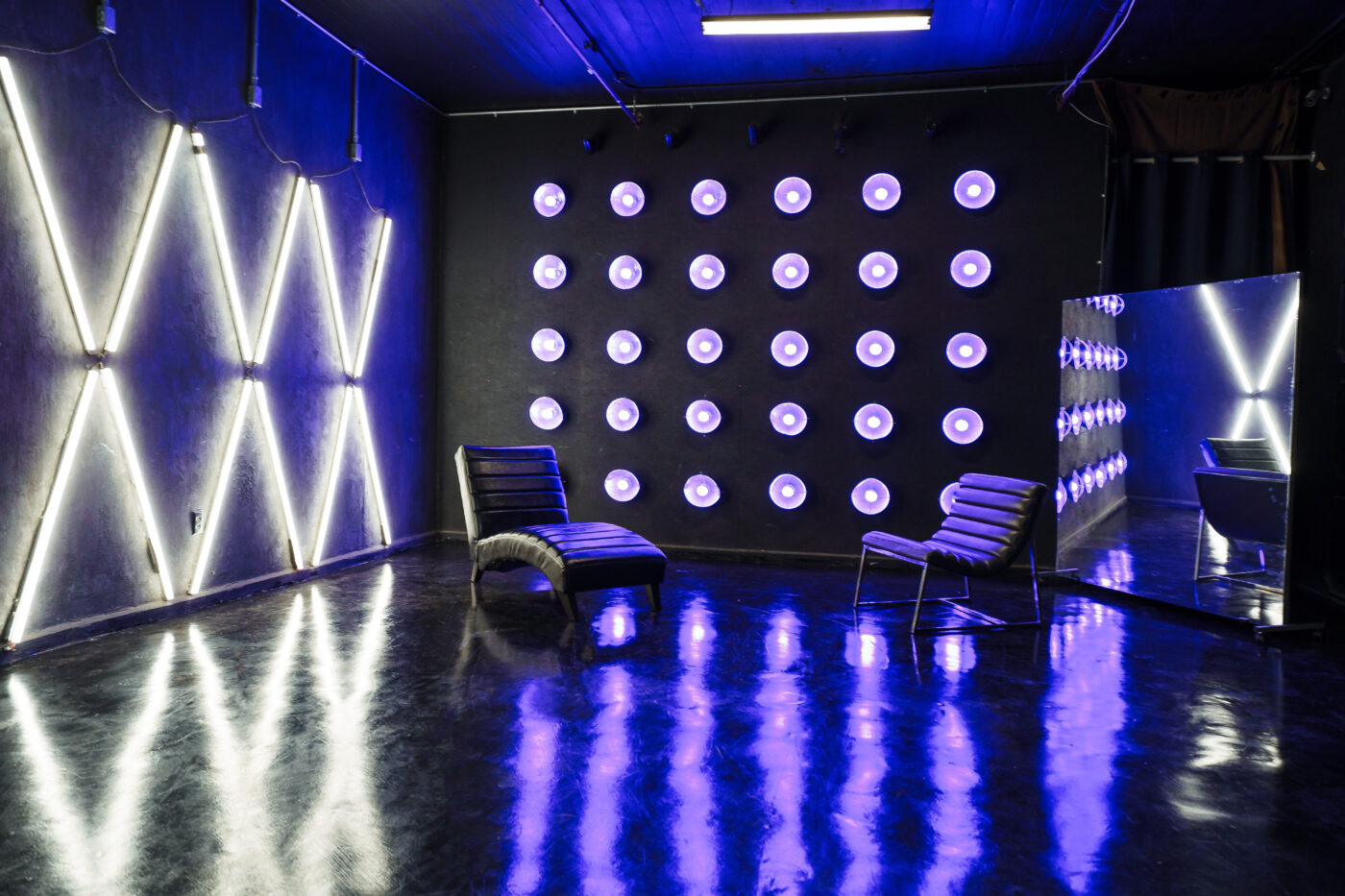 LIC 4 - a Blackout Studio for rent near me New York with RGB lights, X-lights, Concrete Wall, Black gloss floor and two different French Walls