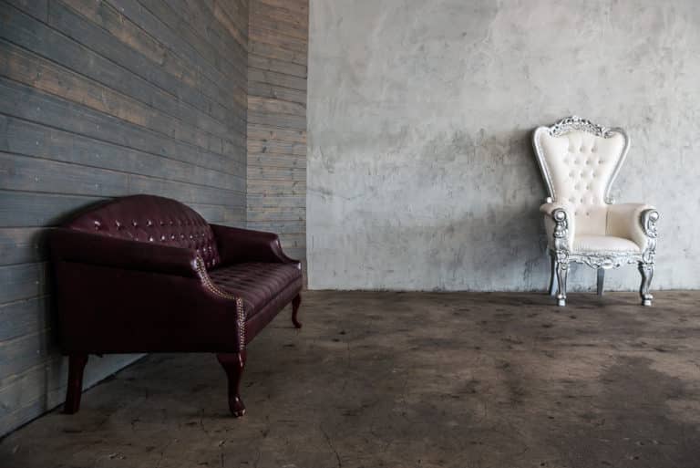 Photo and Video studio with concrete textured wall, red sofa and white extra large chair available for rental In Los Angeles