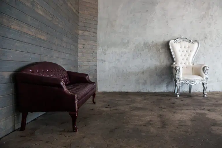 Photo and Video studio with concrete textured wall, red sofa and white extra large chair available for rental In Los Angeles