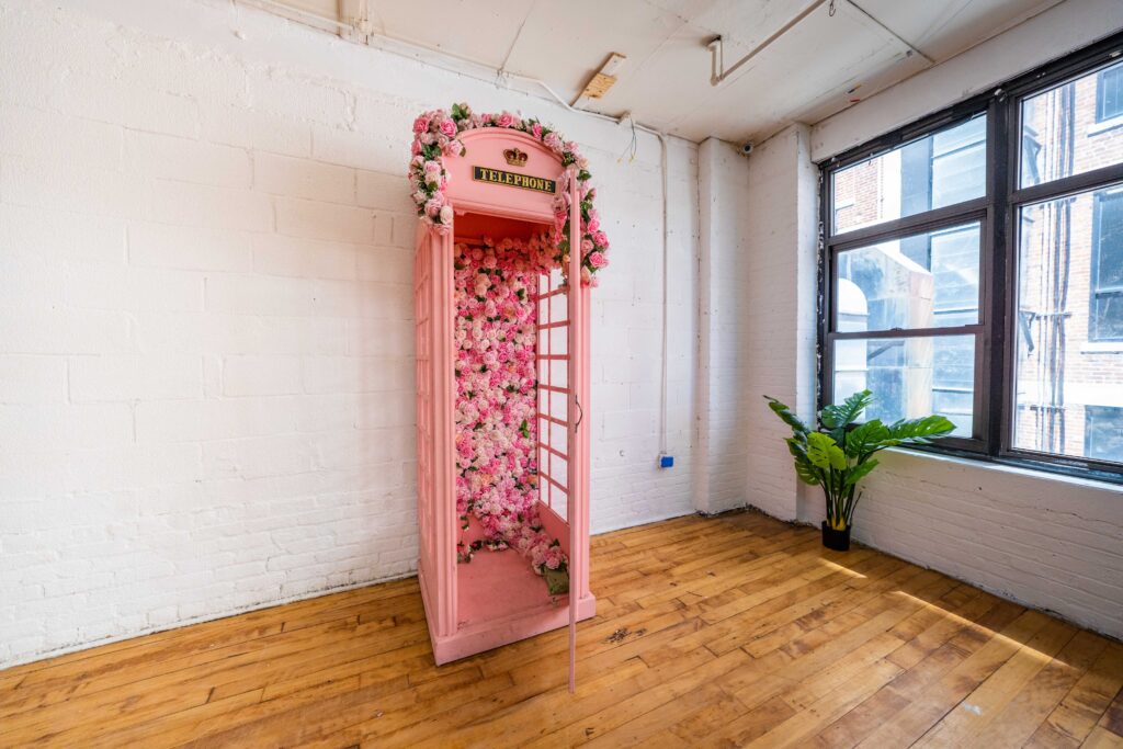 Astoria 3 - photo studio with large window, brick walls, wooden floor and a photo booth FD Photo STudio NY