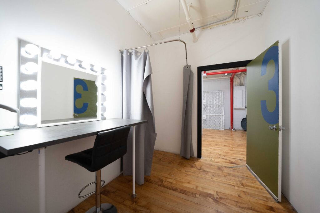 Astoria 3 - photo studio with large window, brick walls, wooden floor and a photo booth FD Photo STudio NY